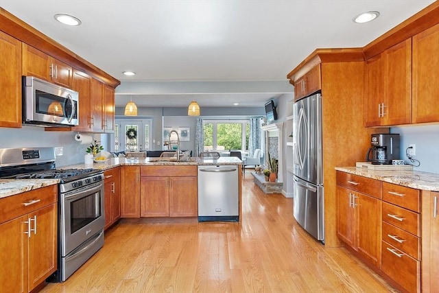9 Crescent Ave, Lynnfield, MA 01940 - kitchen featuring stainless steel appliances, a peninsula, light wood-type flooring, brown cabinets, and light stone countertops