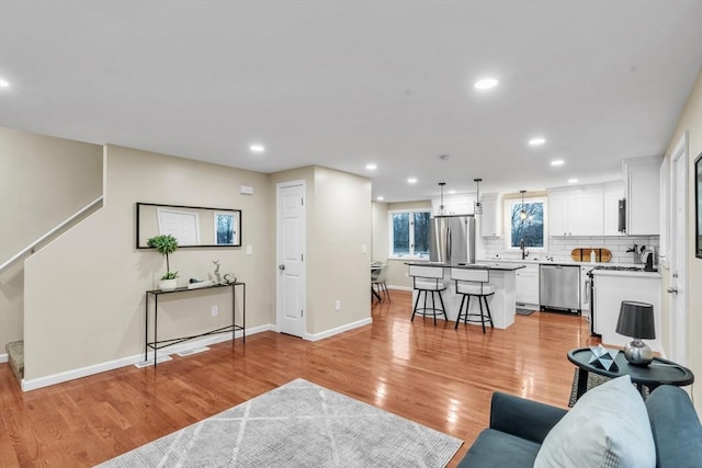 living room with light hardwood / wood-style flooring and sink