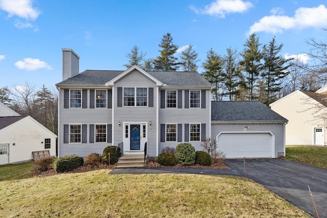 colonial-style house with a front yard and a garage