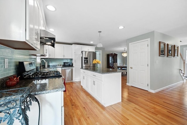 kitchen featuring a kitchen island, white cabinets, pendant lighting, and decorative backsplash