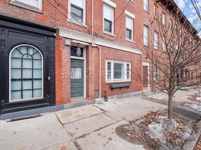 entrance to property featuring brick siding