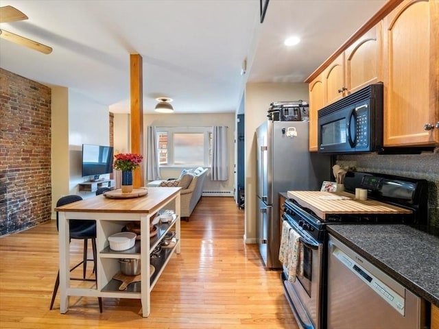 kitchen featuring stainless steel appliances, light wood-type flooring, baseboard heating, and brick wall