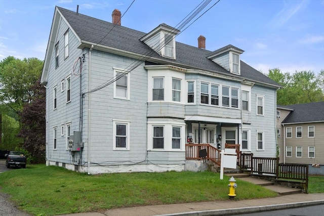 view of front of home with a chimney and a front yard