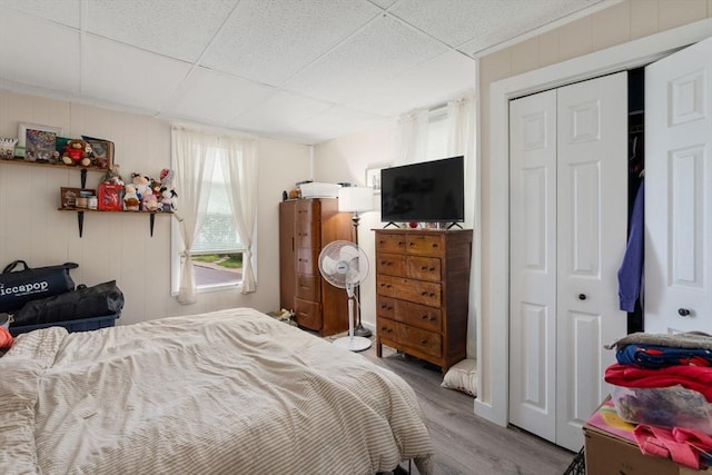 bedroom featuring a paneled ceiling, a closet, and wood finished floors