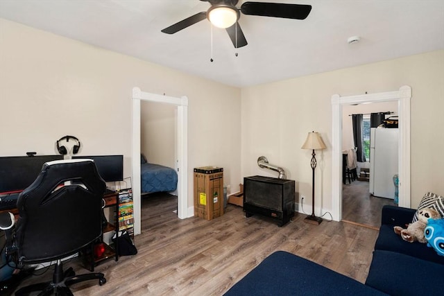 office space with baseboards, ceiling fan, and wood finished floors