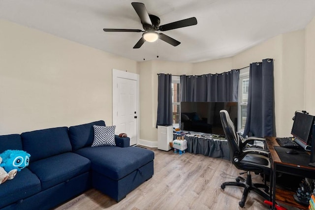 office space with ceiling fan, baseboards, and light wood-style floors