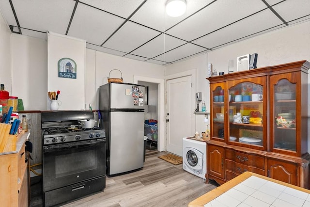 kitchen featuring freestanding refrigerator, light wood finished floors, and black range with gas cooktop