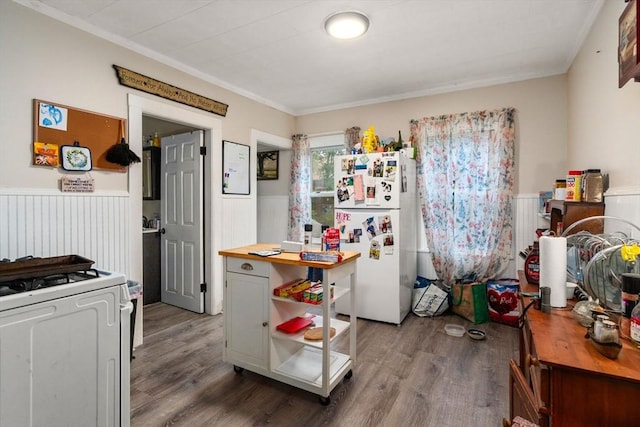 kitchen with white appliances, wainscoting, crown molding, and wood finished floors