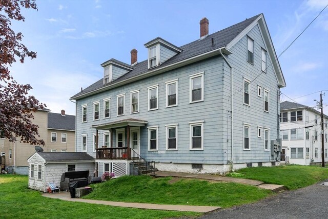 view of front of house featuring a chimney and a front lawn