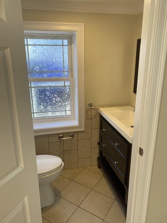 bathroom featuring vanity, a wealth of natural light, tile patterned floors, and toilet