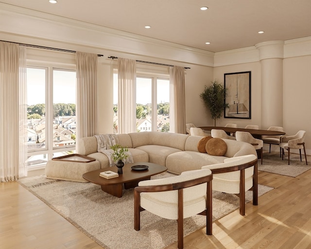 living room featuring light hardwood / wood-style flooring, ornamental molding, and decorative columns