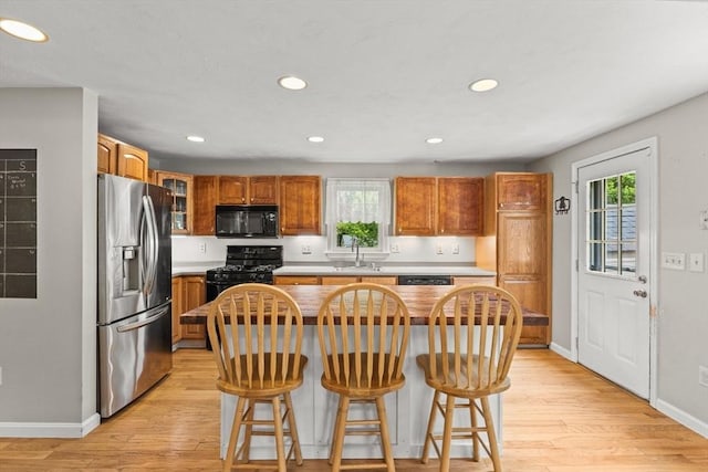 31 Fearing Hill Rd, Wareham, MA 02571 - kitchen featuring black appliances, a sink, baseboards, light wood-type flooring, and a center island