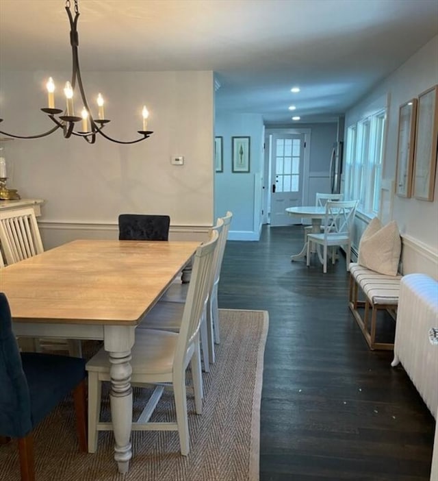 dining space featuring dark wood-type flooring and radiator heating unit