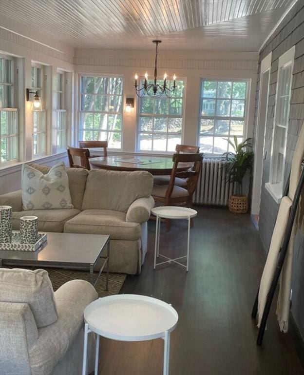 sunroom / solarium with a notable chandelier, radiator heating unit, and wooden ceiling