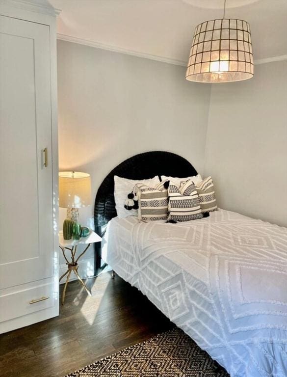 bedroom with ornamental molding and dark hardwood / wood-style floors