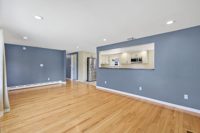 unfurnished living room featuring visible vents, baseboards, baseboard heating, recessed lighting, and light wood-style floors