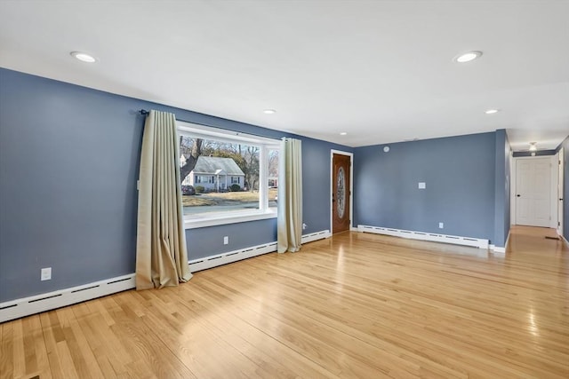 empty room with light wood-style flooring, recessed lighting, and baseboard heating