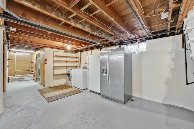 unfinished basement featuring washing machine and clothes dryer, stainless steel fridge, and white refrigerator with ice dispenser