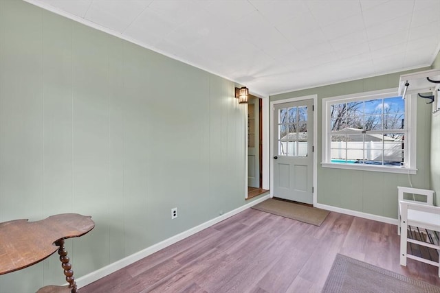 foyer with baseboards, wood finished floors, and crown molding