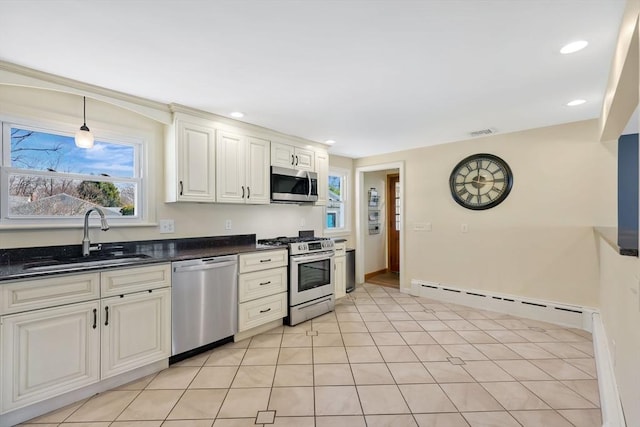 kitchen featuring visible vents, a sink, a baseboard heating unit, recessed lighting, and stainless steel appliances