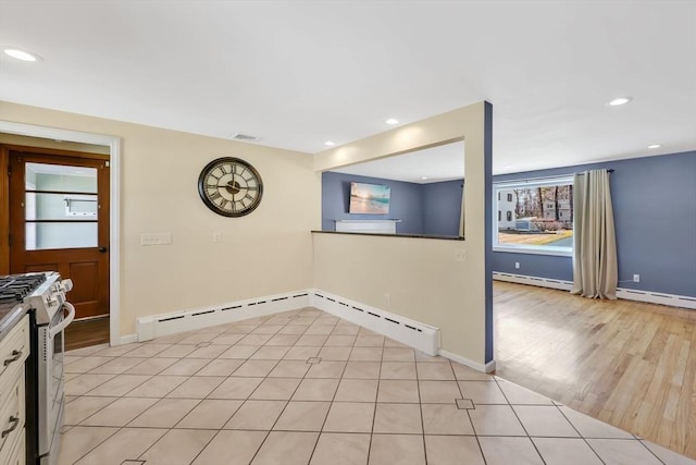 kitchen featuring recessed lighting, a baseboard heating unit, gas range gas stove, and visible vents