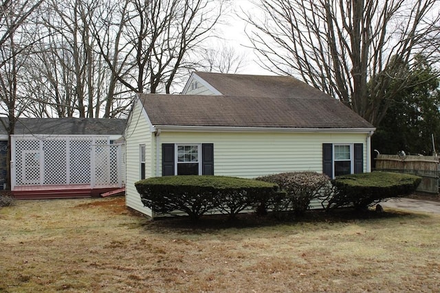 view of home's exterior featuring fence and a lawn