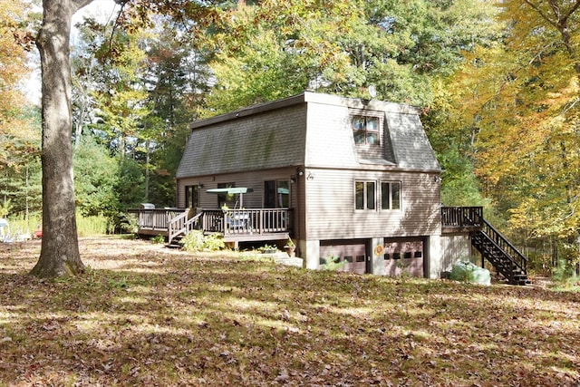 back of property featuring a deck and a garage