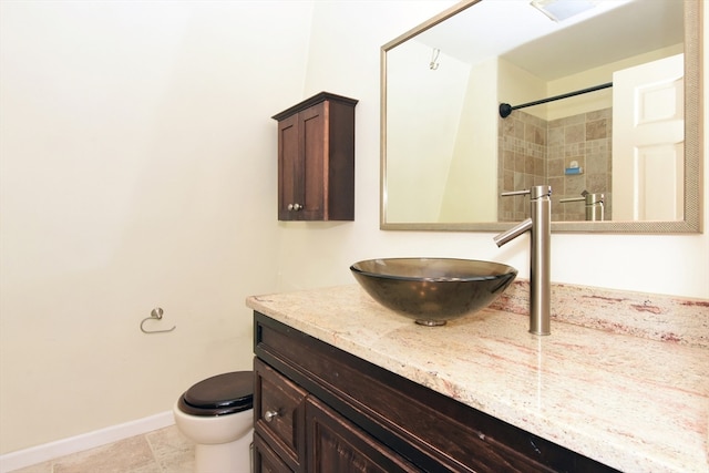 bathroom featuring tiled shower, tile patterned flooring, vanity, and toilet