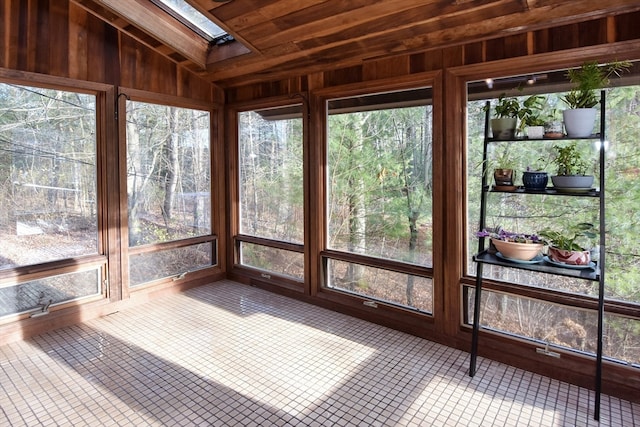 unfurnished sunroom featuring lofted ceiling with skylight