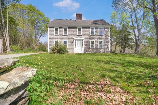 view of front of house featuring a chimney and a front lawn