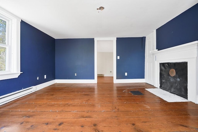 unfurnished living room featuring visible vents, a fireplace with flush hearth, baseboards, a baseboard radiator, and wood-type flooring