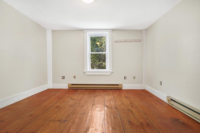 empty room with baseboards, baseboard heating, hardwood / wood-style flooring, and a baseboard radiator