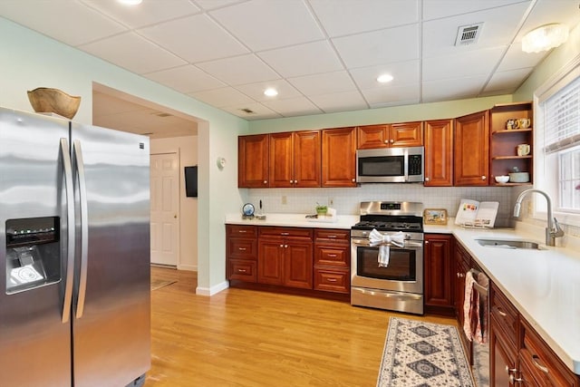 4 Fiske Ave, Chelmsford, MA 01863 - kitchen featuring appliances with stainless steel finishes, light countertops, light wood finished floors, backsplash, and open shelves
