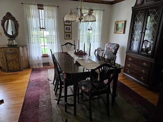 dining area featuring wood-type flooring and a notable chandelier