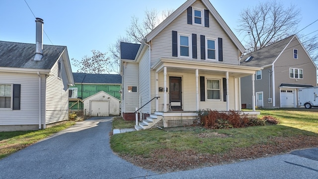 view of front of property with a garage, a porch, an outbuilding, and a front lawn