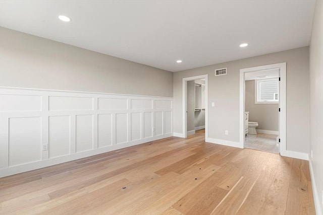 308 Newton St, Waltham, MA 02453 - unfurnished bedroom featuring light wood-type flooring, connected bathroom, a walk in closet, recessed lighting, and a closet