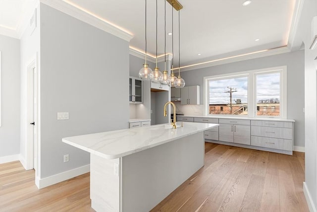 308 Newton St, Waltham, MA 02453 - kitchen with a sink, ornamental molding, light wood-type flooring, baseboards, and light stone countertops