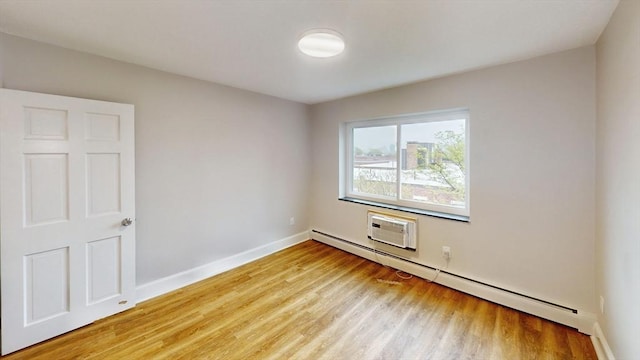 unfurnished room with baseboards, a baseboard radiator, and light wood finished floors