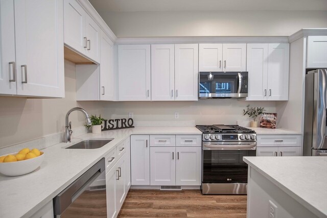 kitchen with sink, white cabinets, and appliances with stainless steel finishes