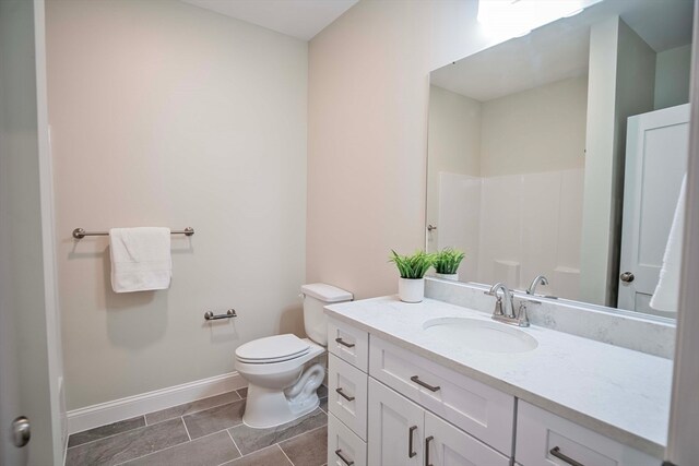 bathroom with walk in shower, tile patterned flooring, vanity, and toilet