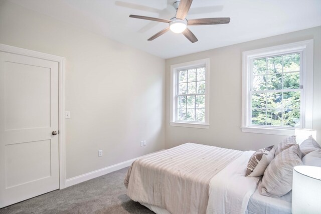 bedroom with multiple windows, light colored carpet, and ceiling fan