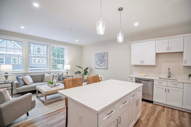 kitchen featuring dishwasher, white cabinets, pendant lighting, light hardwood / wood-style floors, and a kitchen island