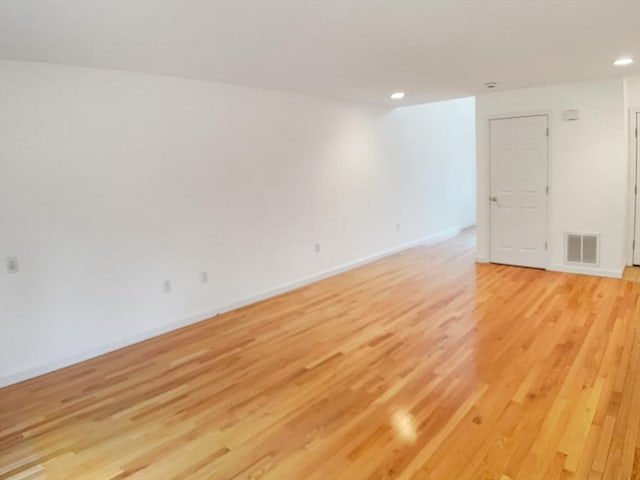 spare room featuring light wood-style floors, recessed lighting, and baseboards