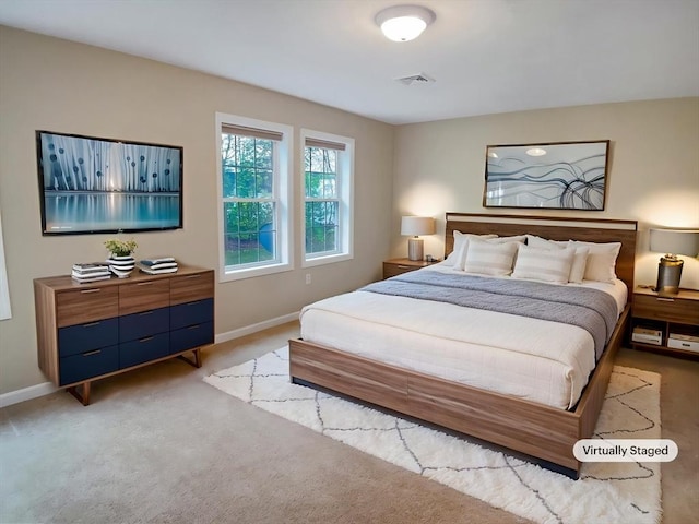 bedroom with baseboards and light colored carpet