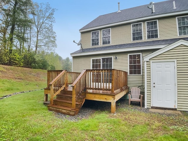 rear view of house with a lawn, a wooden deck, and a shingled roof