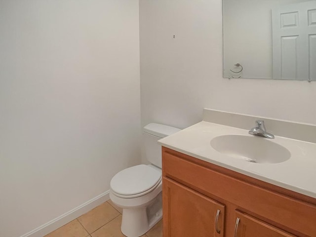 half bathroom featuring tile patterned flooring, toilet, and vanity