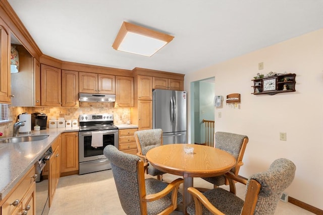 55 Glen Rd, Wilmington, MA 01887 - kitchen featuring appliances with stainless steel finishes, under cabinet range hood, a sink, decorative backsplash, and light countertops