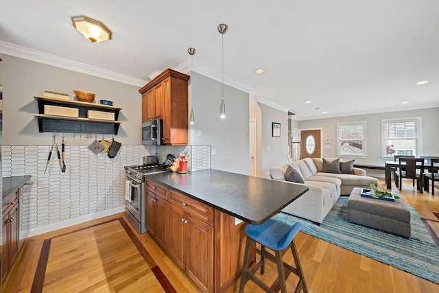 867 Adams St Unit 867, Boston, MA 02124 - kitchen featuring appliances with stainless steel finishes, light wood-style floors, brown cabinetry, dark countertops, and a peninsula