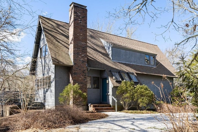 view of front of house with a chimney and roof with shingles