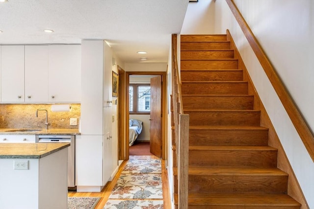 staircase with recessed lighting and wood finished floors